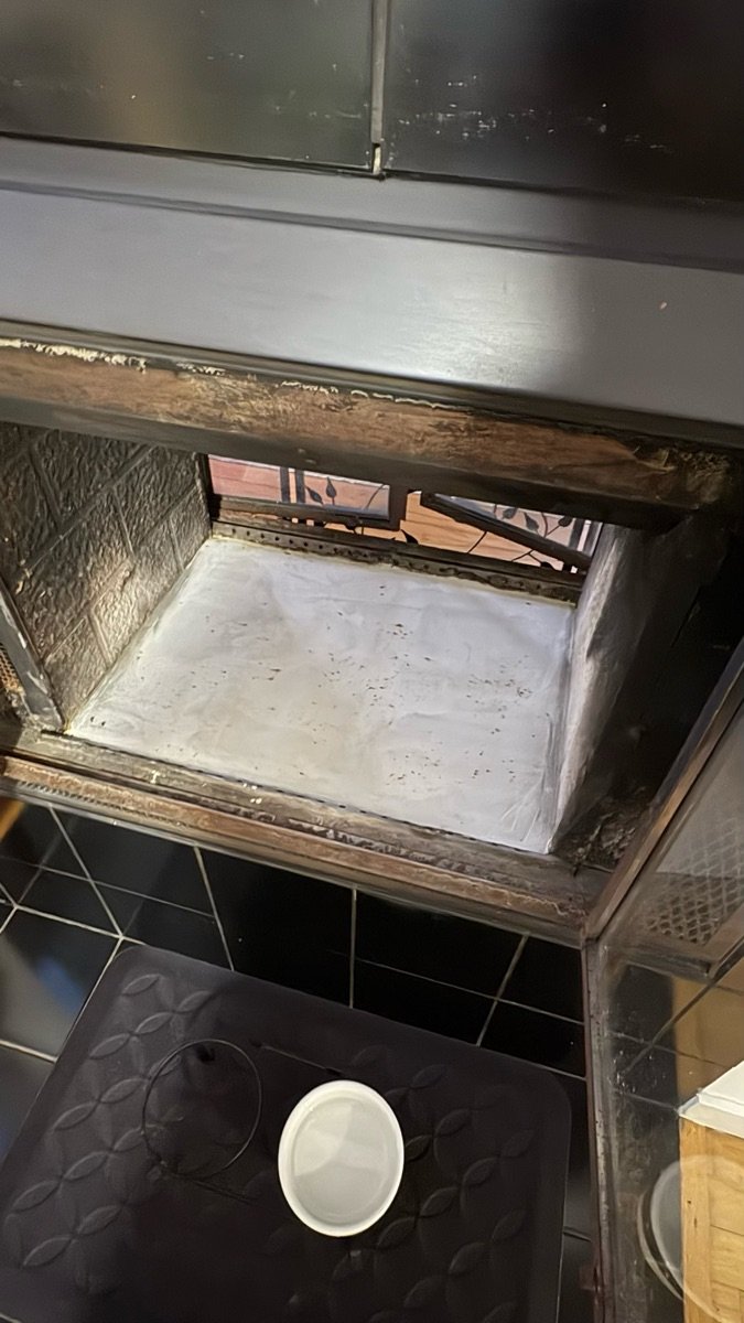 Fireplace interior showing water damage and deterioration requiring repair